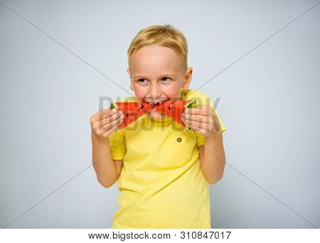 Frolicsome Caucasian 5 Year Old Boy Without Incisor Capering And Eating Pieces Of Red Watermelon, De