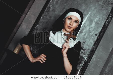 Sexy Nun Prays Indoor . Beautiful Young Holy Sister. Young Beautiful Nun With A Cross In A Robe In A