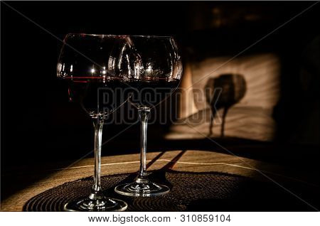 Two Glasses Of Red Wine With Shadows From The Rays Of The Setting Sun. Objects, Close-up, Still Life