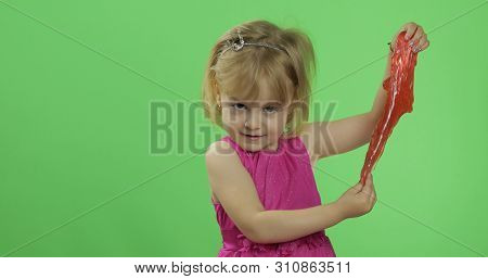 Child Having Fun Making Red Slime. Kid Playing With Hand Made Toy Slime. Funny Kid Girl. Relax And S
