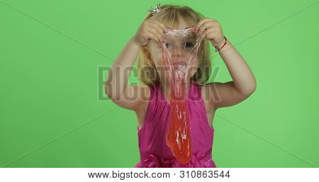 Child Having Fun Making Red Slime. Kid Playing With Hand Made Toy Slime. Funny Kid Girl. Relax And S