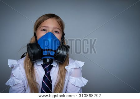 Young Schoolchild In Gasmask Closeup Portrait. Effect Of Pollution On Small Children, Preteens. Dang