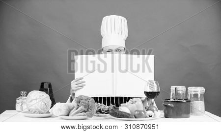 She Is A Super Cook. Lady Cook Looking For Cooking Recipe In Cookbook. Pretty Woman Reading Cook Boo