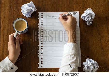 I Am Sorry Written On Paper With Coffee On Wooden Table Hands Of A Person