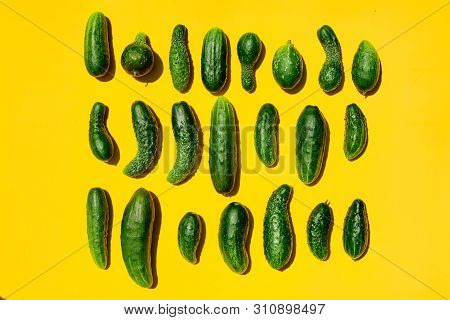 Different Sizes Forms Cucumbers Pattern On A Light Yellow Background. Copy Space.