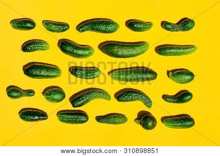 Different Sizes Forms Cucumbers Pattern On A Light Yellow Background. Copy Space.
