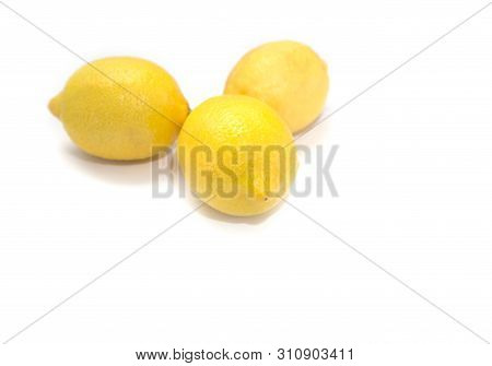 Three Yellow Lemons And Ginger Root On A Light Background.