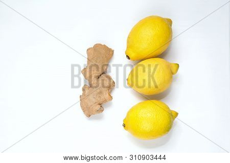 Three Yellow Lemons And Ginger Root On A Light Background.