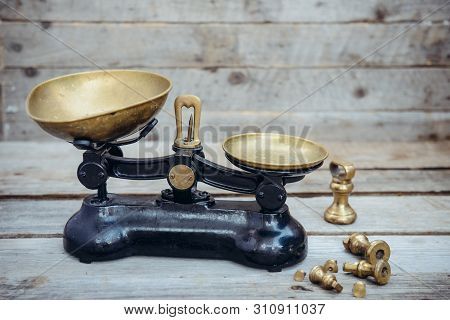 Antique Vintage Measuring Scale Weights With Brass Trays On The Wooden Rustic Background. Selective 