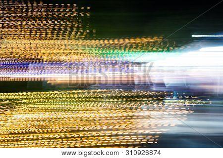 Abstract Of Multicolored Lights Stripes Moving Fast In Dark Background. Orange Violet And Bluel Back