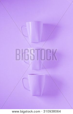 3 Purple Coffee Mugs On Purplish Background In A Vertical Row, Empty Copy Space