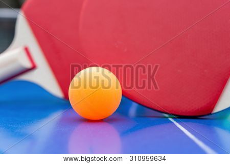 Pingpong Rackets And Ball And Net On A Blue Pingpong Table
