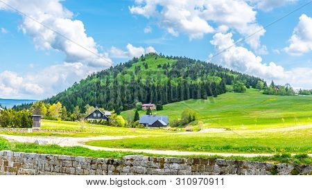 Bukovec Mountain Above Jizerka Village. Summer Landscape With Green Meadows, Blue Sky And White Clou