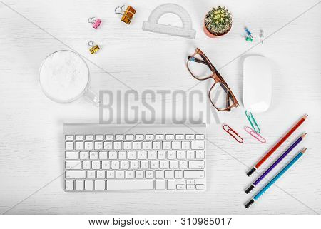 White Office Desk Table With Computer Mouse And Keyboard, Cup Of Latte Coffee, Pencils And Eye Glass