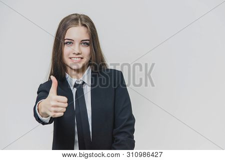 Female Hand Gestures Thumb Up. Business Girl Is Smiling Broadly And Shares Positive Emotions.