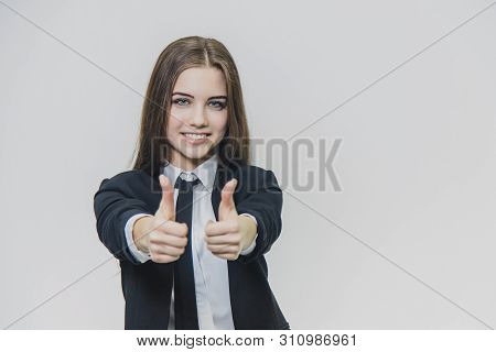 Female Hand Gestures Thumbs Up. Business Girl Is Smiling Broadly And Shares Positive Emotions.