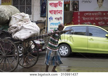 Kolkata, India, August 2017, Old Man Pulling Hath Ricksahaw Or Hand Pulled Cart On A Road