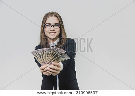 Happy Excited Young Business Woman Is Showing A Pile Of Money, Isolated On White Background. Girl Is
