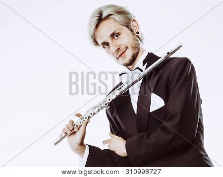Classical Music Study Concept. Male Flutist Musician Performer Playing Flute. Young Elegant Man Wear