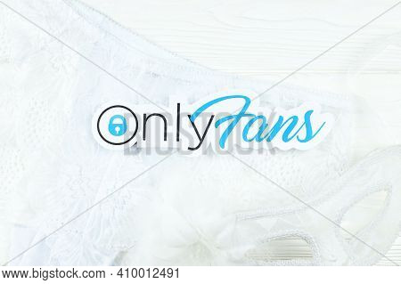 Kharkov, Ukraine - February 14, 2021: Onlyfans Paper Logo And White Lingerie With Carnival Mask On W