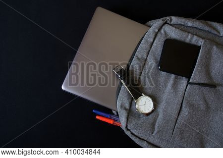 A Fashionable Silver Ultrabook Or Laptop And Smartphone Lie In A Modern Textile City Backpack, On Wh