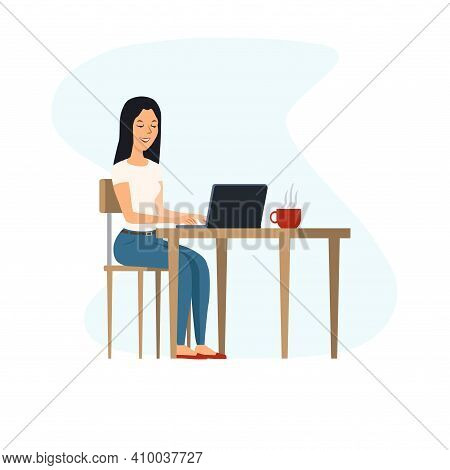 Young, Happy Woman Sitting At The Table And Working On A Laptop. Nearby Is A Cup Of Hot Coffee.