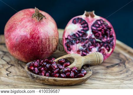 A Red Pomegranate And A Half On Olive Wood