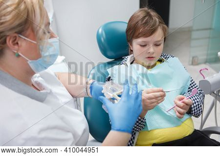 Young Boy Talking To His Dentist After Dental Checkup