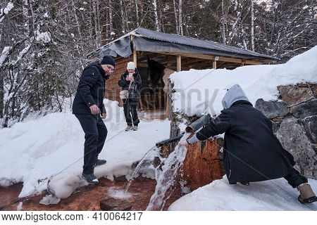 Kislovodsk, Russia - January 24, 2021: In Winter, People Filling Bottles And Glasses With Healing Wa