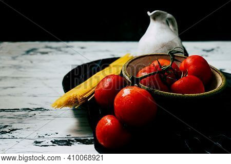 Uncooked Spaghetti,  Organic Tomatoes And Jug Of Olive Oil