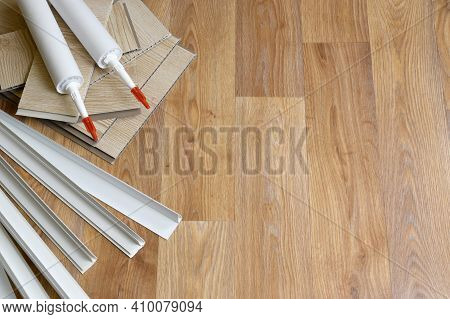 Set Of Items For Pvc Ceiling Indoor Works. Assembly Adhesive Bottles And Pvc Panels With Plastic Cor