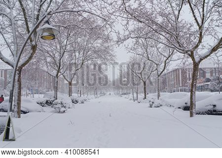 Streets And Buildings Covered In Snow By Day Due To Snowstorm Filomena Falling In Madrid Spain. Peop
