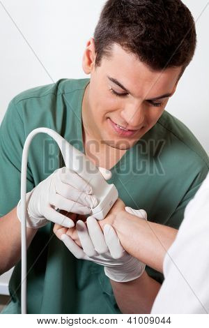 Mladý muž radiolog ošetřujícím mužský pacient s ultrazvukem