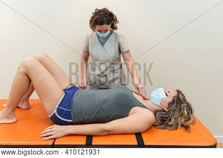 Physiotherapist And Patient In Global Postural Re-education Session, With Pandemic Protection Mask.