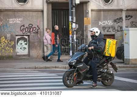 Belgrade, Serbia - February 21, 2021: Glovo Delivery Man Wearing A Face Mask Protective Respirator I