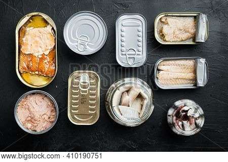 Salmon, Tuna, Trout Mackerel And Anchovy - Canned Fish In Tin Cans Set, On Black Background, Top Vie