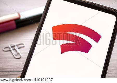 Red Stadia Logo On Mobile Phone Display Gaming. Game Platform On Smartphone Screen Holding Hand. Ita
