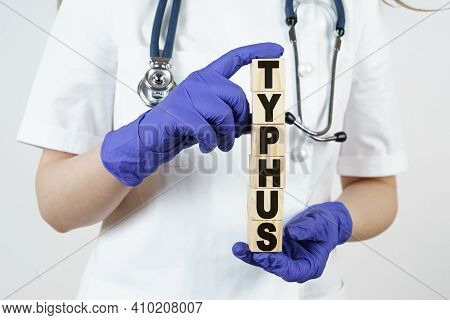 Medicine And Health Concept. The Doctor Holds Cubes In His Hands On Which It Is Written - Typhus