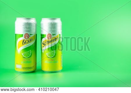 Bangkok, Thailand - February 28, 2021 : Photo Two Can Of Schweppes Manao Soda On A Green Background.