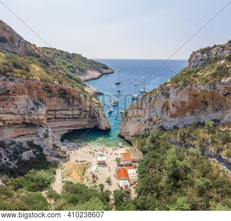 Aerial View Of Tourists Sunbath Swim At Stiniva Cove Beach Of Adriatic Sea On Vis Island In Croatia 