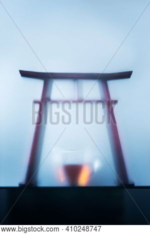 Torii Gate Silhouette With A Teacup, Blue Misty Background With Copy Space