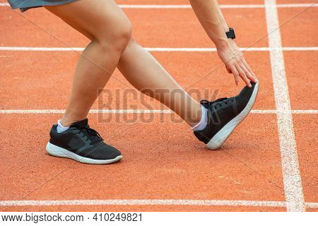 Cropped Shot View Of Runner Woman Doing Stretching And Warming Up Her Legs Before Running In The Run