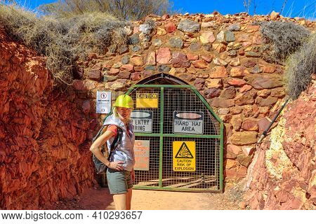 Happy Woman Tourist With Miners Helmet At Entrace Of Tunnel Cave Of Battery Hill Mining Center. Tour