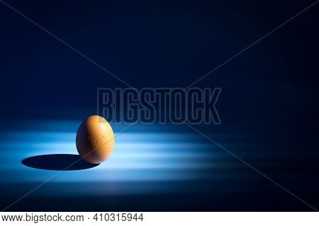 Easter Egg Minimal Concept On A Blue Background With Rays Of Light. There Are Morning Light On The I