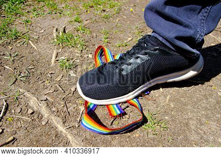 Trampling Of Lgbt Flag In Dirt By Radical Homophobe. Rainbow Lgbt Tape Is Stamped With Feet.