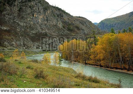 A Turn Of A Beautiful Turquoise River Flowing Calmly Through An Autumn Valley Surrounded By High Mou