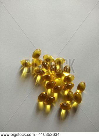 Herbal Oil, Cold Pressed Vitamin Capsule, Body Care Drug. Yellow Shiny Oil Health Supplement