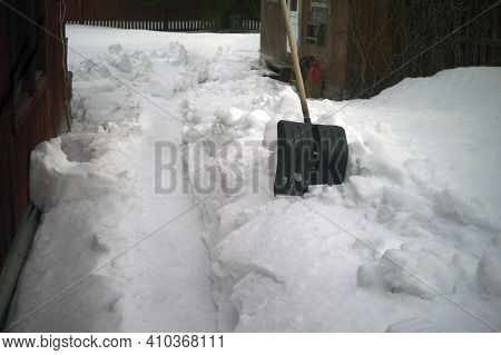 A Shovel And A Passage Dug In The Snowy Yard