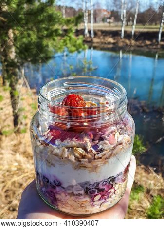 Healthy Breakfast Overnight Oats With Strawberries, Blueberries And Yoghurt In A Glass Jar With Beau