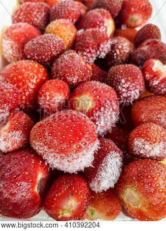 Macro Shot Of Frozen Strawberries With Frost On Them In A Plastic Container On White Background